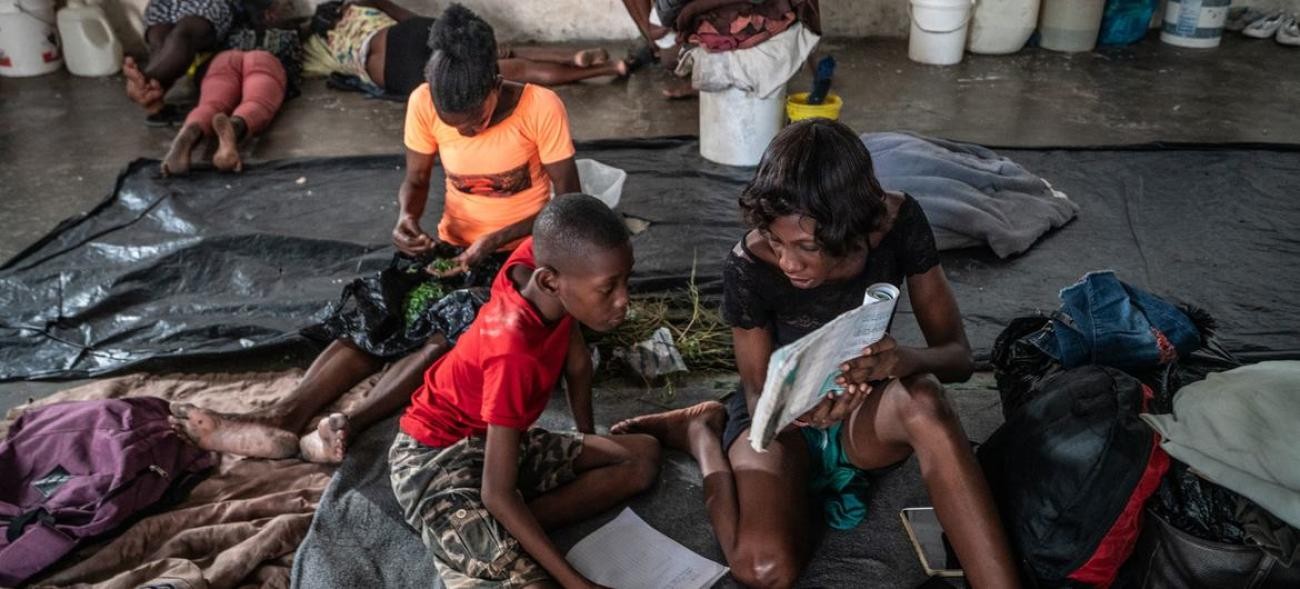 A mother helps her child study in the Delmas 4 boxing arena